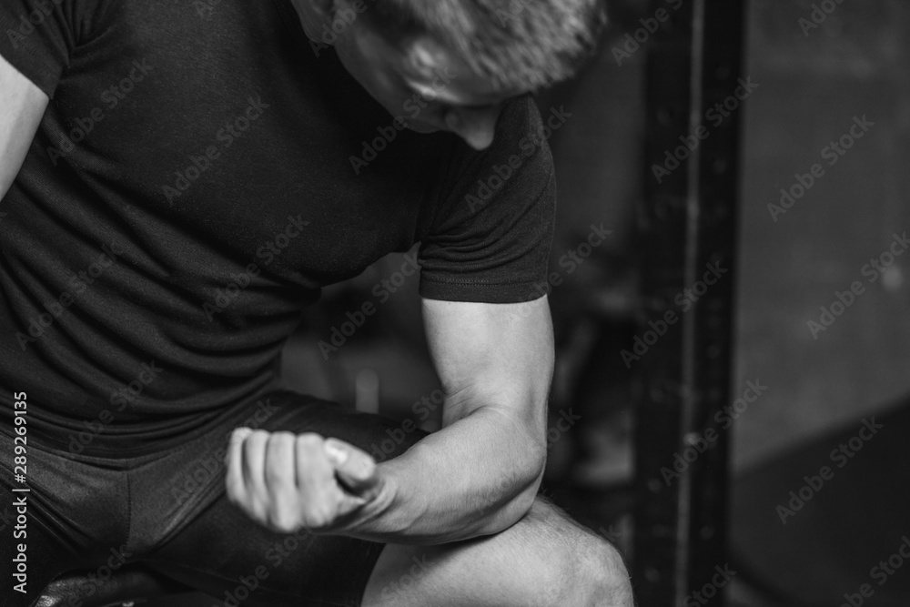 Young man in the gym. Healthcare. Lifestyle. A sexy man dressed in a black T-shirt. Caucasian Bodybuilder is nourished body.