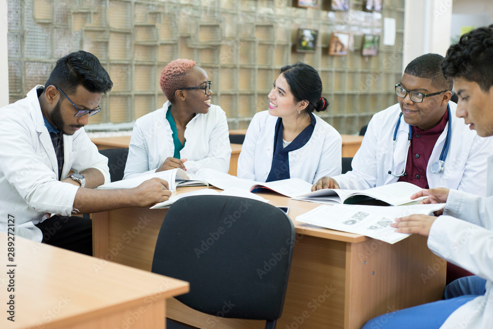 a group of young doctors, mixed race. Sit at the table discussing medical topics. a group of young doctors, mixed race. Sit at the table discussing medical topics.