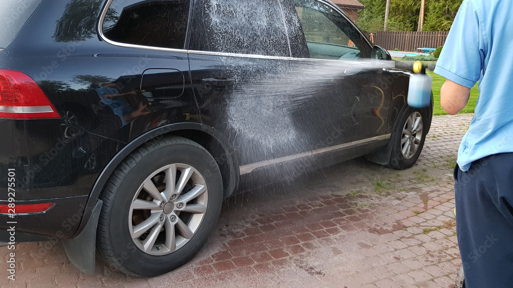 Manual car washing with high pressure power washer, cleaning dirty auto outside. Manual car washing with high pressure power washer, cleaning dirty auto outside.