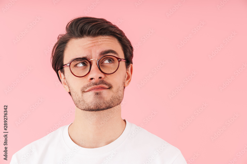 Image of thinking caucasian man wearing eyeglasses looking upward at copyspace Image of thinking caucasian man wearing eyeglasses looking upward at copyspace