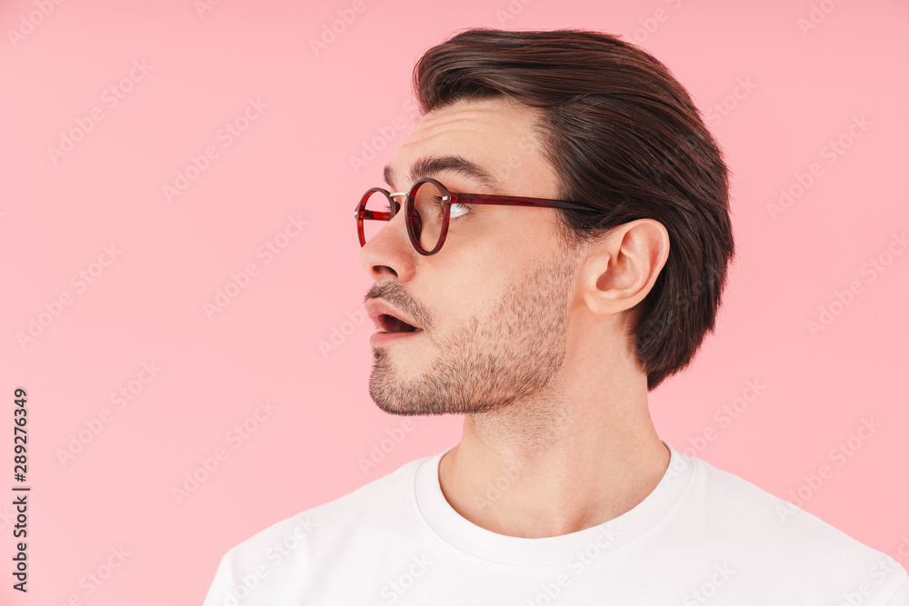 Image in profile of surprised caucasian man wearing eyeglasses smiling and looking forward