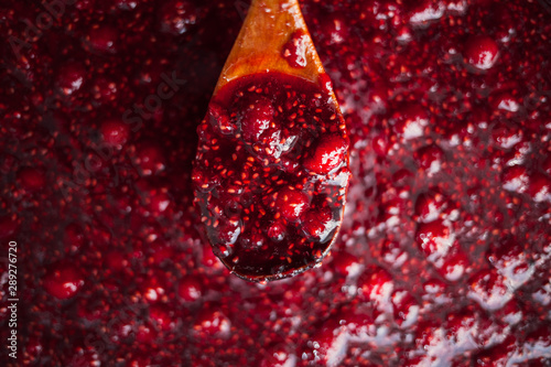 raspberry jam is kept with a wooden spoon