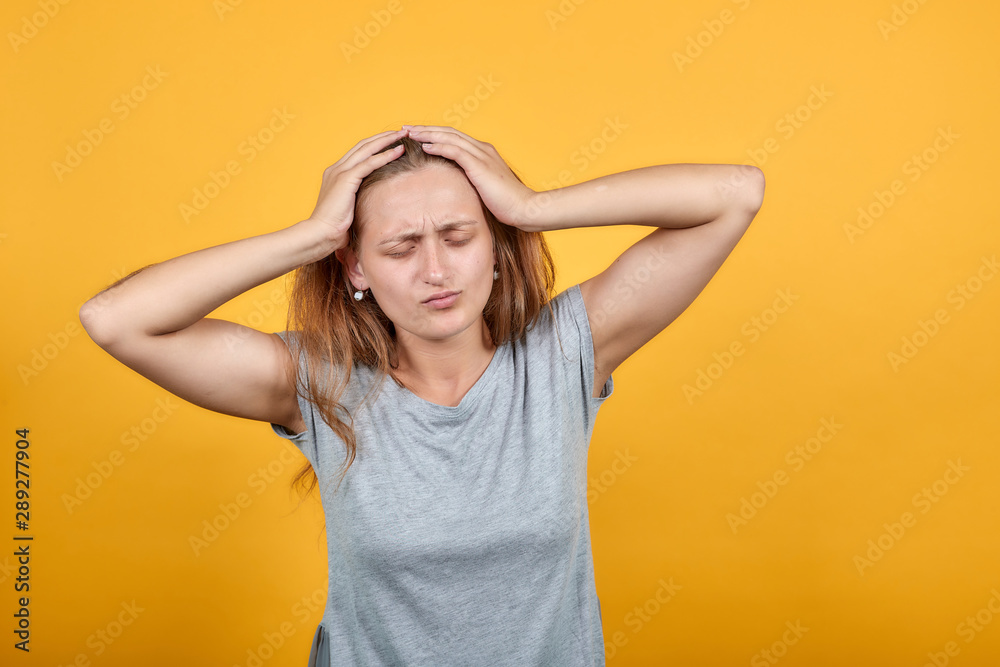 brunette girl in gray t-shirt over isolated orange background shows emotions brunette girl in gray t-shirt over isolated orange background shows emotions