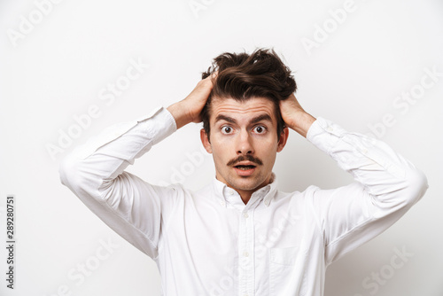 Portrait closeup of shocked mustached man wearing shirt looking at camera and grabbing his head