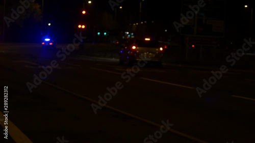 British Police Cars With Blue Lights On Their Way To An Emergency Late At Night In Britain, Nottingham. Blue Flashing Lights Hand Held