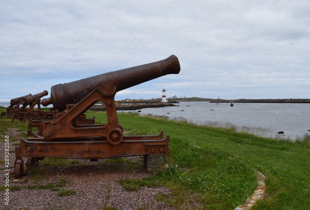 lighthouse and canons at Point aux Canons on Saint Pierre island, Ile aux Marion in the background  Saint Pierre and Miquelon