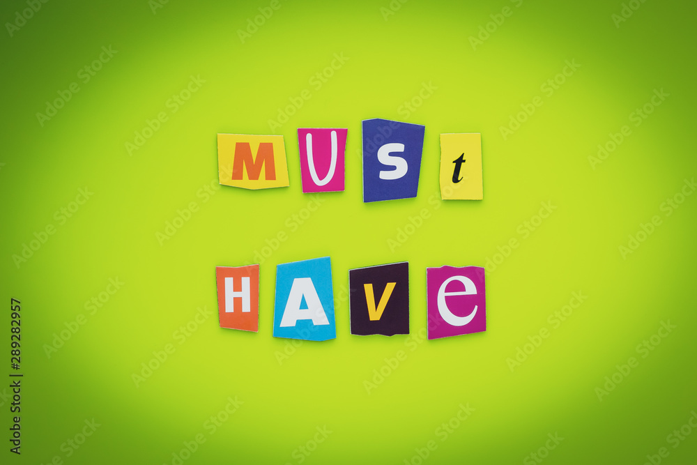 A word writing text - must have. Cut letters on a yellow and green background. Headline, banner. Colorful inscription on a board, paper. Success concept. A word writing text - must have. Cut letters on a yellow and green background. Headline, banner. Colorful inscription on a board, paper. Success concept.