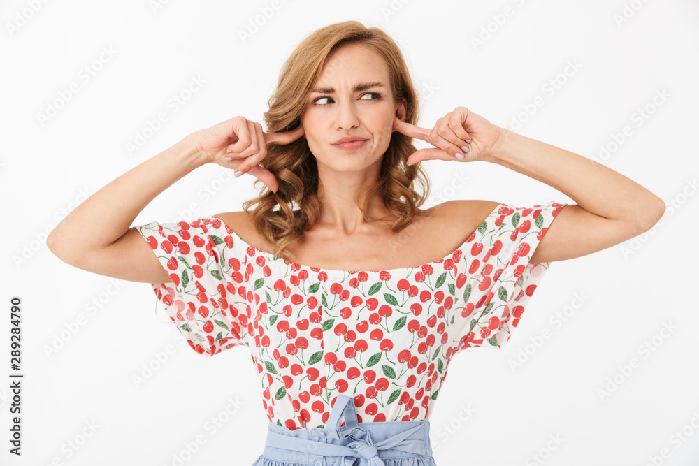 Portrait of confused caucasian woman wearing summer clothes looking aside and closing her ears Portrait of confused caucasian woman wearing summer clothes looking aside and closing her ears