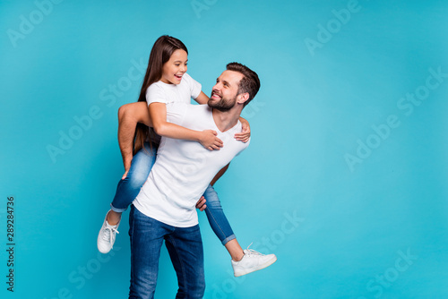 Foto Portrait of cheerful man holding his kid with brunette hairstyle piggyback weari
