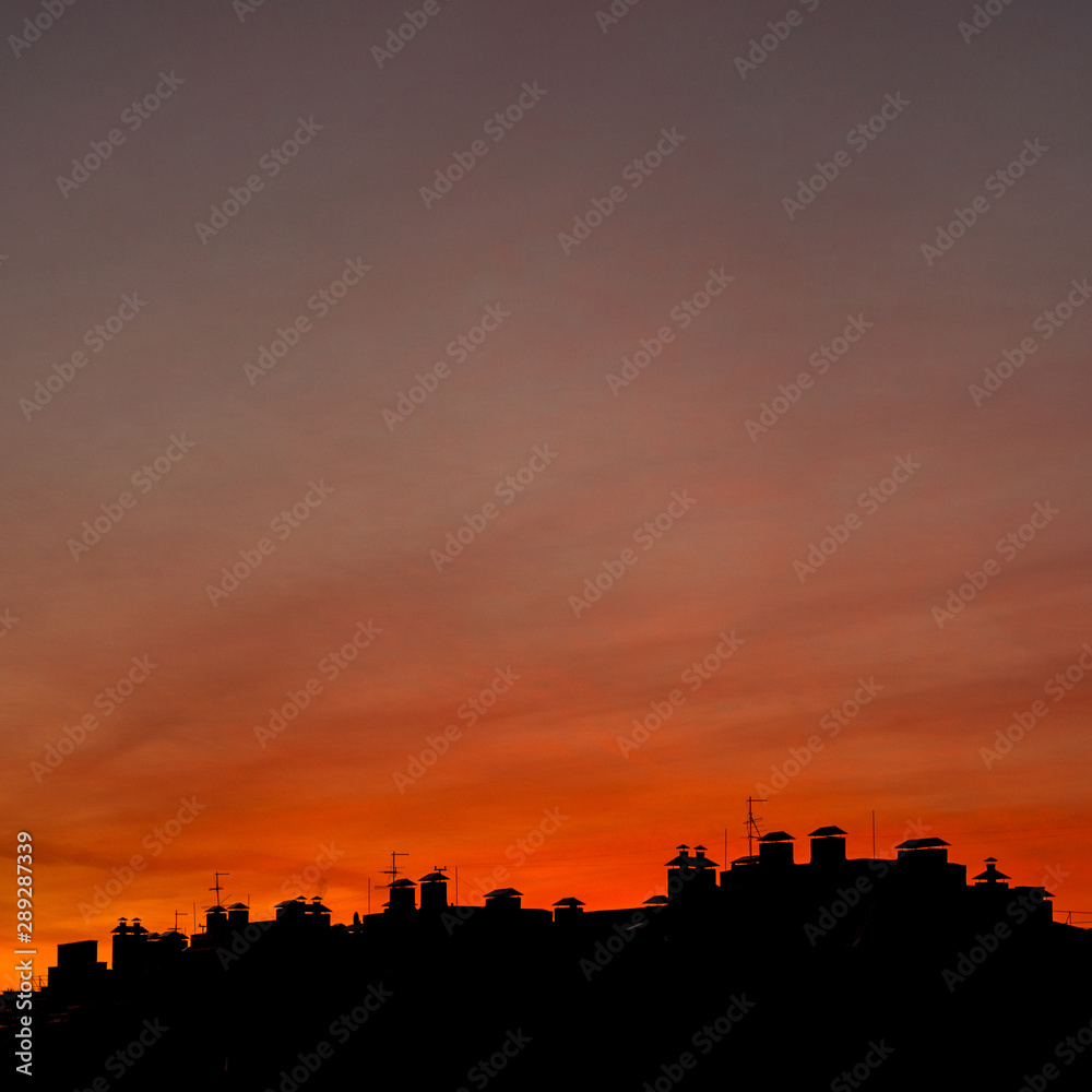 Roofs of houses on a background of a beautiful sunset
