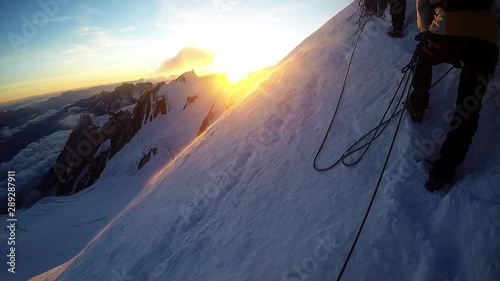 Group of climbers reaches the top of mountain peak. Climbing and mountaineering sport.