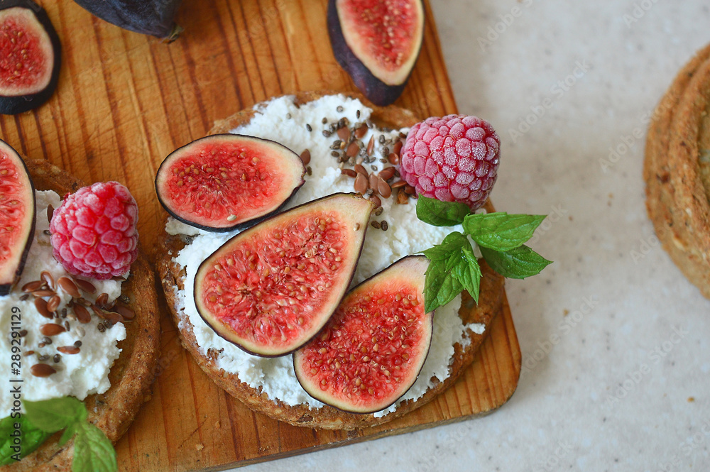 Figs, cheese and honey on round sandwiches on white background.The concept of proper nutrition.