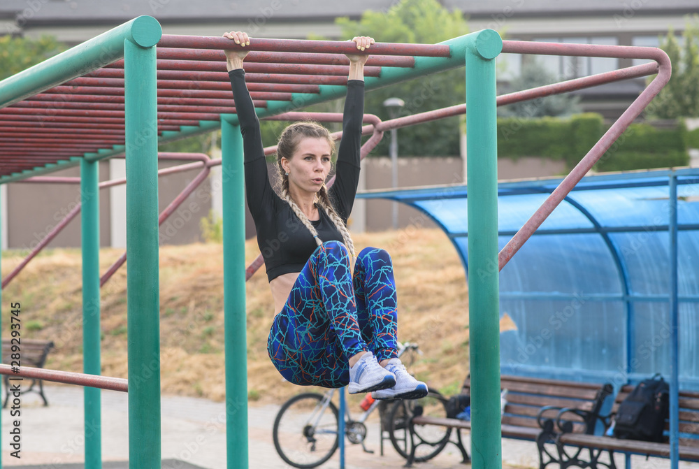 Obraz premium athletic girl doing exercises on the abs on the playground