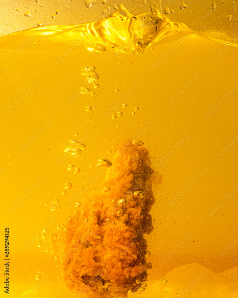 Obraz premium Chicken fried in yellow oil
