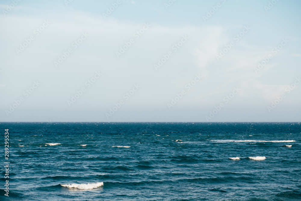 Fototapeta premium Blue sea with waves and cloudy sky background. Atlantic ocean. 