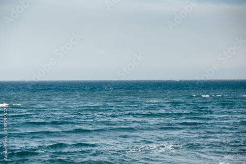 Blue sea with waves and cloudy sky background. Atlantic ocean. 