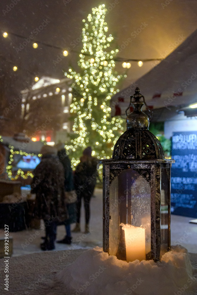 Lamp with the candle at the Christmas market at night