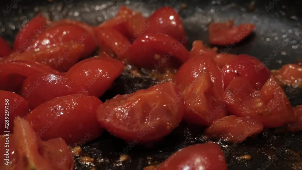 Juicy diced raw tomato chunks being fried in a pan, closeup Juicy diced raw tomato chunks being fried in a pan, closeup