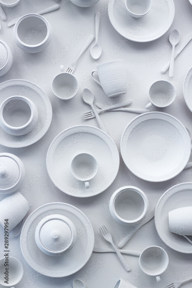 Many dishes and appliances are painted white on a white surface, the concept of excessive consumption, selective focus Many dishes and appliances are painted white on a white surface, the concept of excessive consumption, selective focus