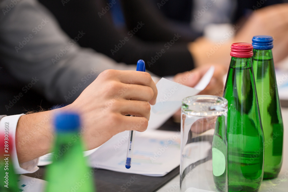 business and people concept - hands of businessman with pen and papers at conference business and people concept - hands of businessman with pen and papers at conference