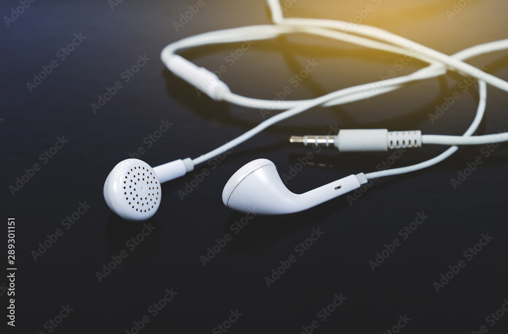 Naklejka premium White in ear headphones on background.Modern portable audio accessory.