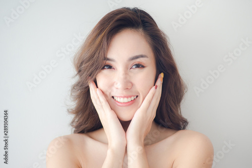 Beauty Asian Woman face Portrait. Beautiful Spa model Girl with Perfect Fresh Clean Skin. Blonde female looking at camera and smiling