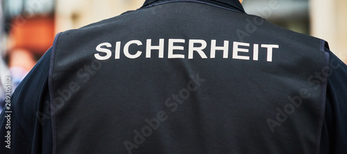 Foto Back view of a guard with a black waistcoat with the German inscription Sicherh
