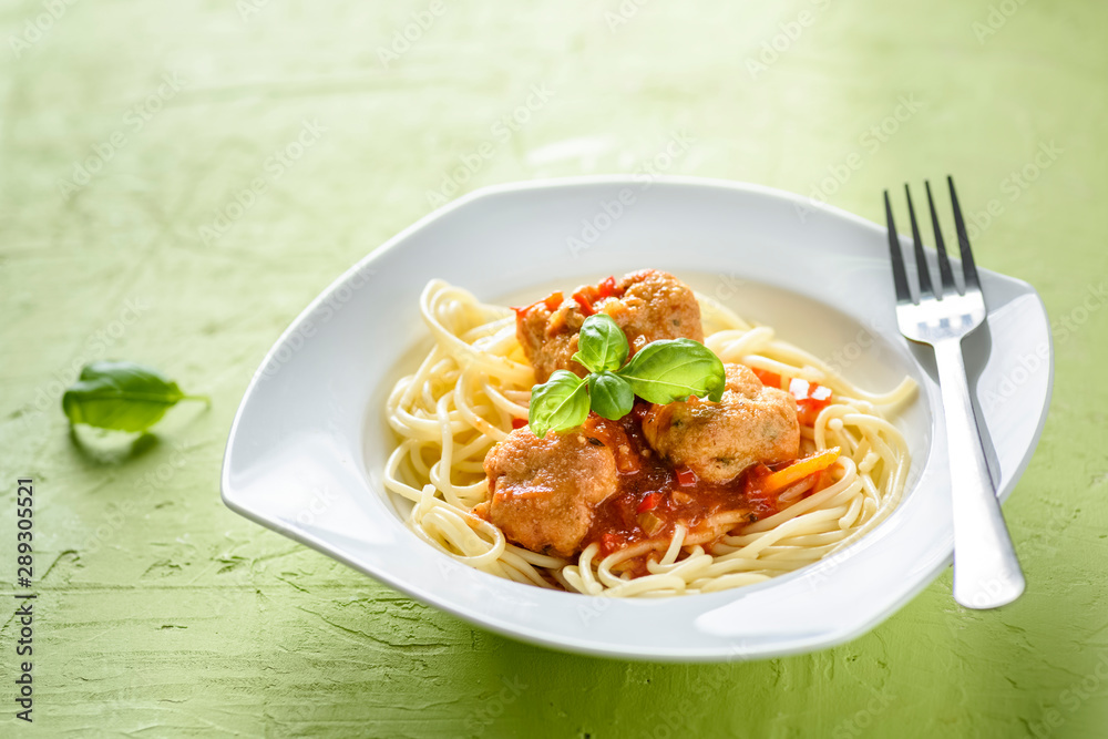 homemade pasta with tomato sauce and cooked meatballs