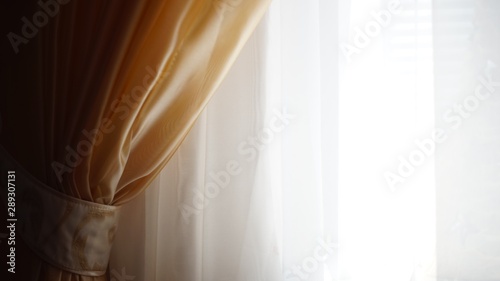 White tulle with a brown curtain fixed holder, light background.