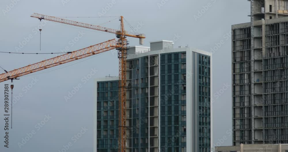 Construction of regular apartments buildings with yellow high cranes Construction of regular apartments buildings with yellow high cranes