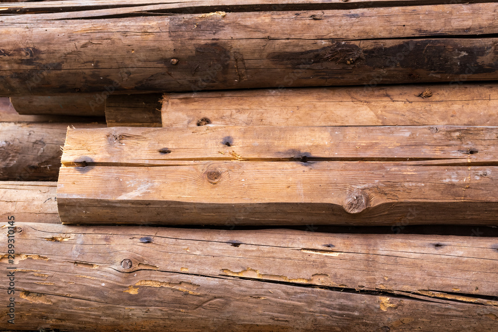 Background in the form of old round wooden logs in light brown color, side view Background in the form of old round wooden logs in light brown color, side view