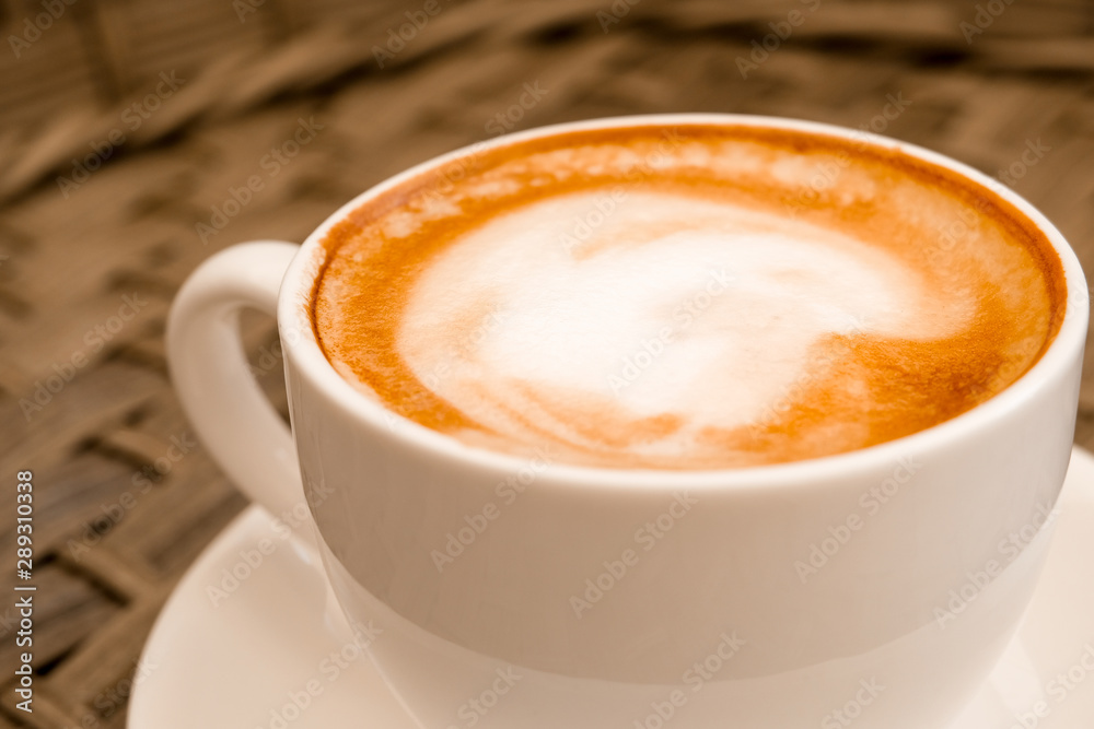close up cappuccino in white cup on wood table background at cafe. Bewerages, coffee lovers and morning menu concept. Stylish toning. close up cappuccino in white cup on wood table background at cafe. Bewerages, coffee lovers and morning menu concept. Stylish toning.