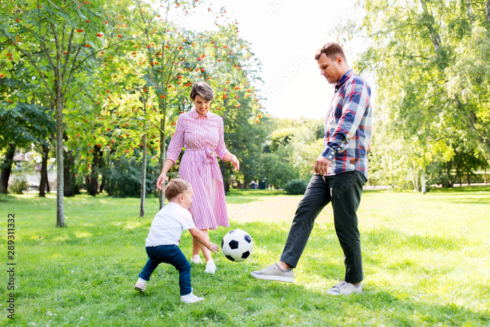 family, leisure and people concept - happy mother, father and little son with ball playing soccer at summer park family, leisure and people concept - happy mother, father and little son with ball playing soccer at summer park