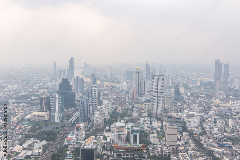 Fototapeta premium Air pollution in Bangkok with PM2.5 air-quality index (AQI) reached dangerous level with dust and smog in hazy sky, threatening to public health, rooftop view