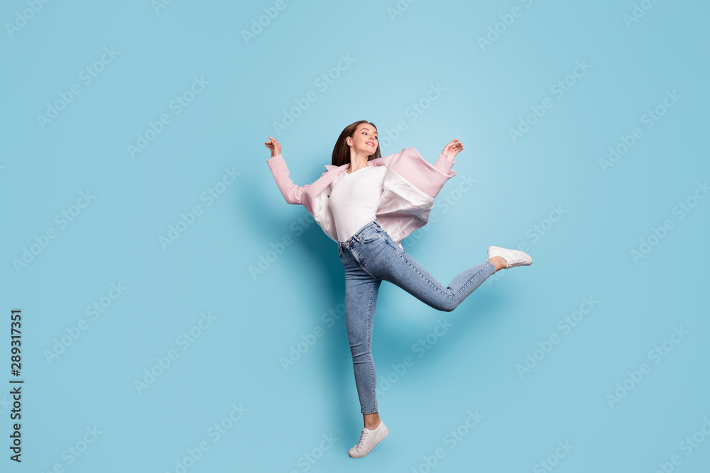 Full length photo of childish funny lovely lady jump have fun wear topcoat isolated over blue background