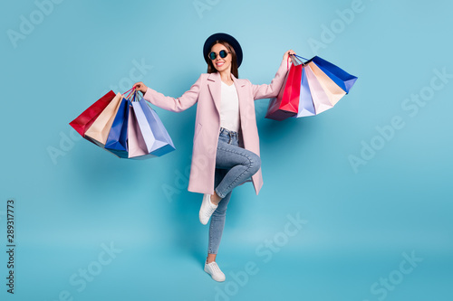Full body photo of dancing rejoicing girl go shopping buy bargains wear retro pink vintage stylish outfit denim jeans eyewear eyeglasses isolated over blue background photo