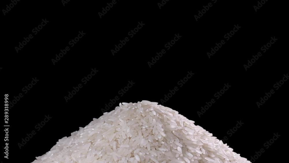 Raw rice grains rotating pattern. White basmati rice grains on black background. Pile of cereal long seeds rice close up. Raw rice grains rotating pattern. White basmati rice grains on black background. Pile of cereal long seeds rice close up.
