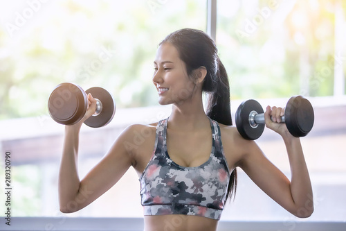 Portrait Of Smiling Young Woman Exercising At Gym