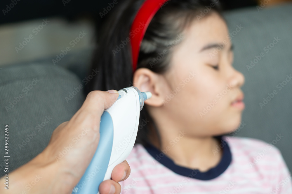 Mother checking temperature her daugther in the ear with ear Thermometer. Mother checking temperature her daugther in the ear with ear Thermometer.