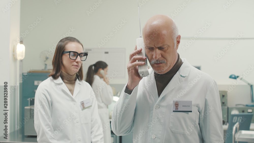 Retro style scientist receiving an important phone call Retro style scientist receiving an important phone call