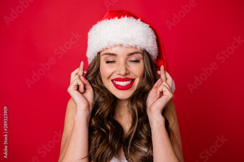 Close up photo of excited woman wait for wish her eyes closed having long wavy hairstyle wearing cap hat dress skirt isolated over red background