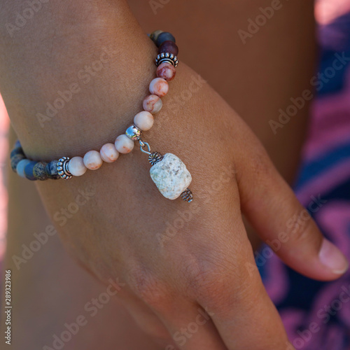 Female hand wearing mineral stone beads yoga bracelet