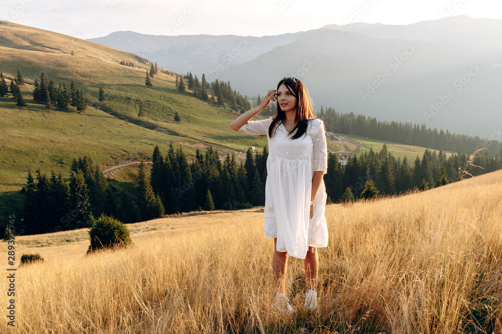 stylish traveler girl in hat with backpack jumping in mountains. happy hipster woman having fun on top of mountain. space for text. wanderlust and travel concept. atmospheric moment stylish traveler girl in hat with backpack jumping in mountains. happy hipster woman having fun on top of mountain. space for text. wanderlust and travel concept. atmospheric moment