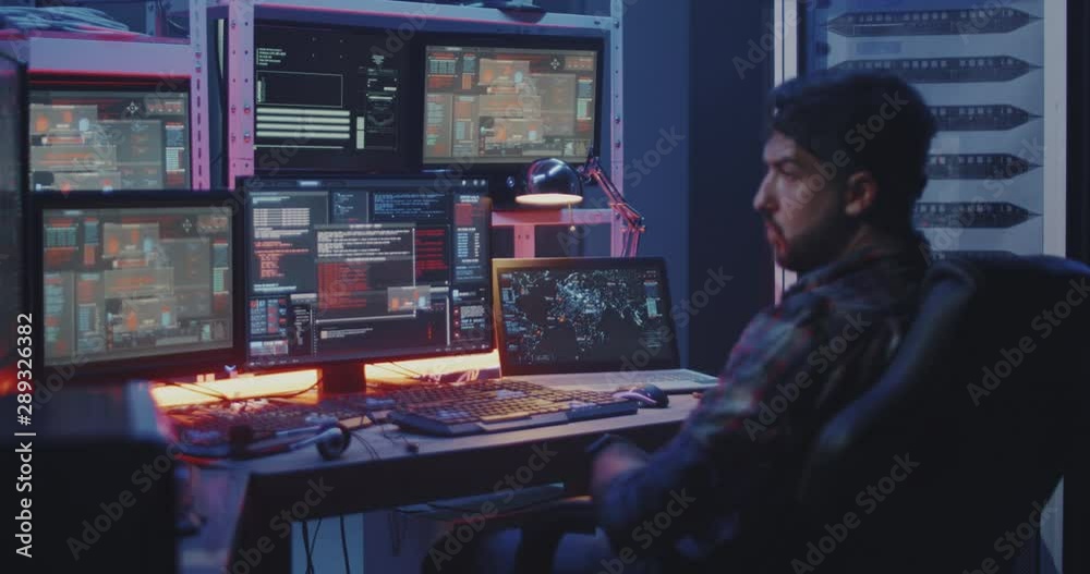 Hacker watching multiple monitors