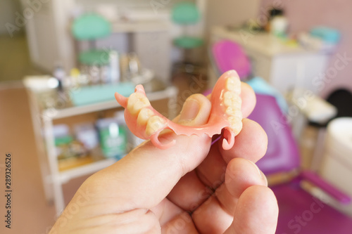 removable denture in the hands of a doctor photo