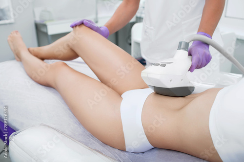 woman having cavitation procedure, cellulite treatment, on her belly and body