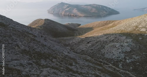Aerial Drone flight in summer over mountains on the island krk near baska in croatia during sunrise over the sea