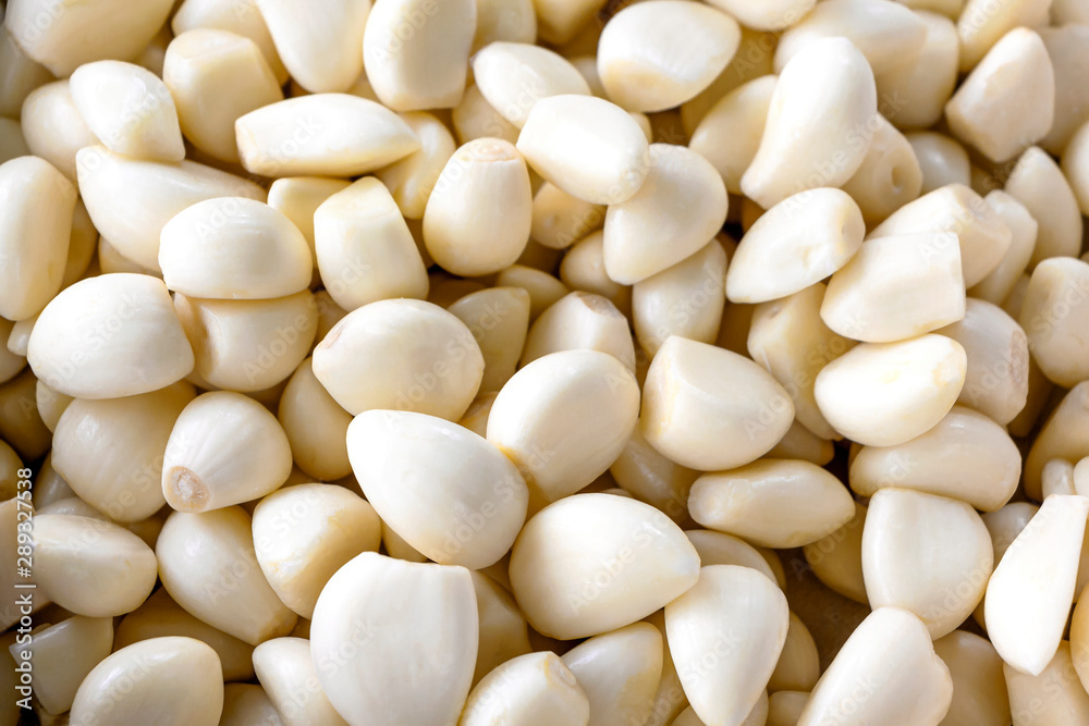 Many peeled garlic has a beautiful white color. It is used as a flavoring in cooking and herbal medicine. Many peeled garlic has a beautiful white color. It is used as a flavoring in cooking and herbal medicine.