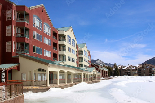Colorado nature background, ski resort vacation concept. Scenic view with Keystone sky resort downtown and mountains around the covered by snow and thawed ice lake in spring sunlight.