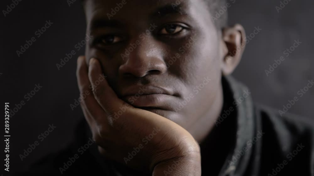 Defocused sad bored african migrant in the dark.Migration,sadness,loneliness Defocused sad bored african migrant in the dark.Migration,sadness,loneliness